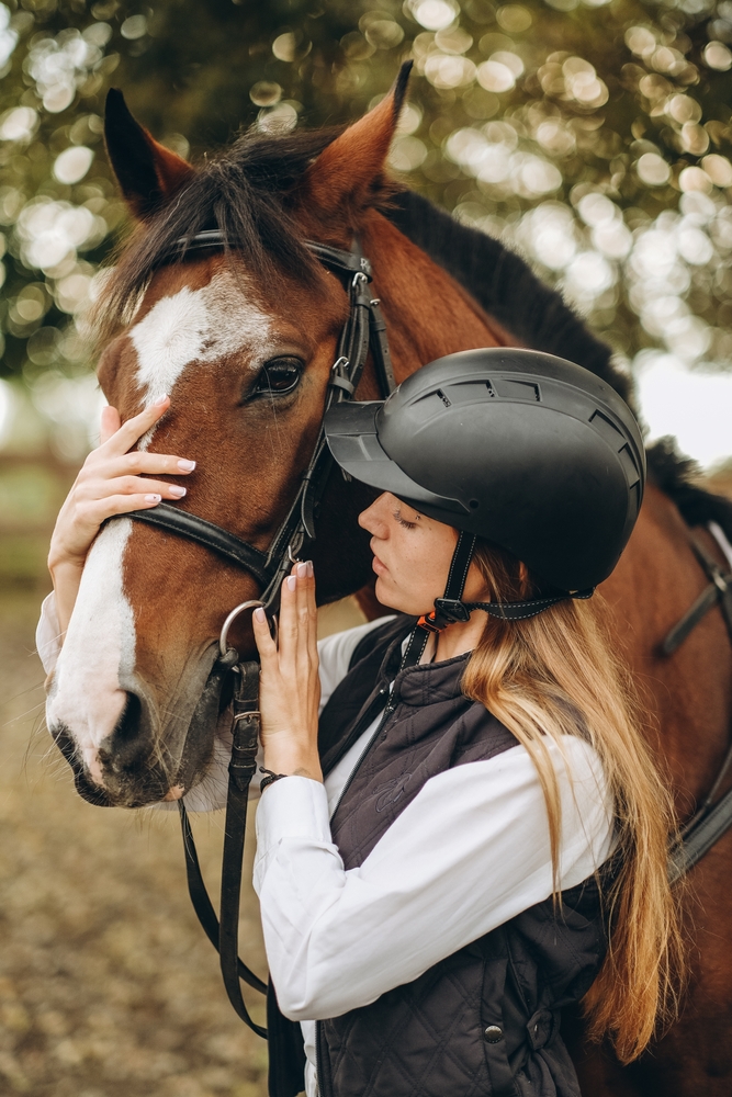 A,Young,Female,Equestrian,Stands,Near,Her,Horse,And,Prepares